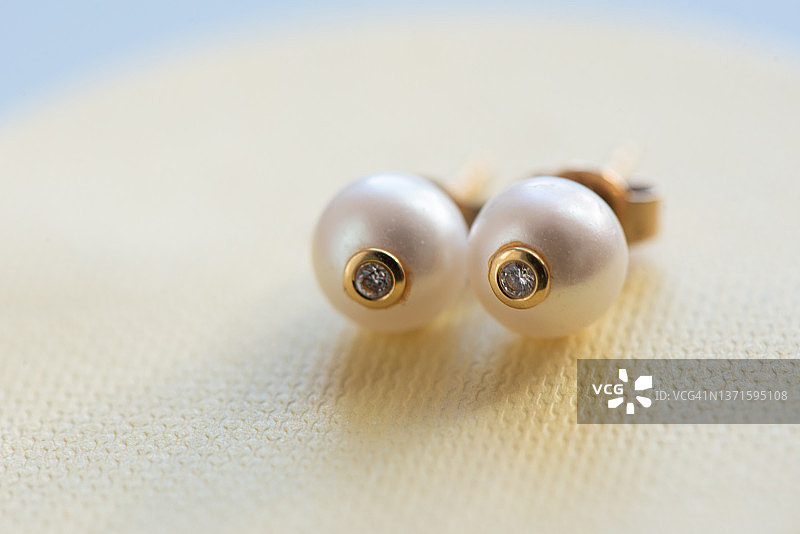浅黄色背景上的水晶珍珠耳环图片素材