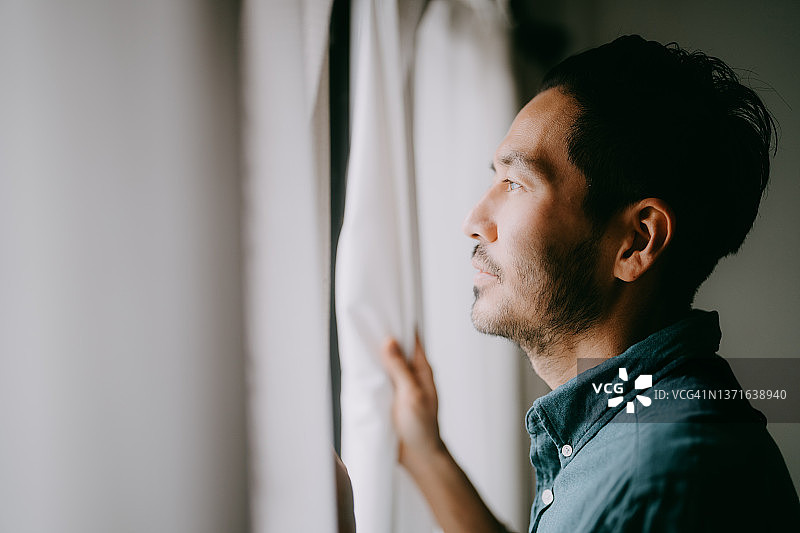 男人从窗户向外看图片素材