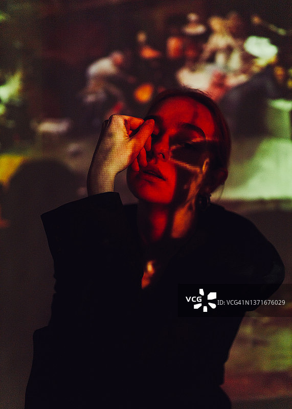 坐在抽象光线中的年轻漂亮女人图片素材