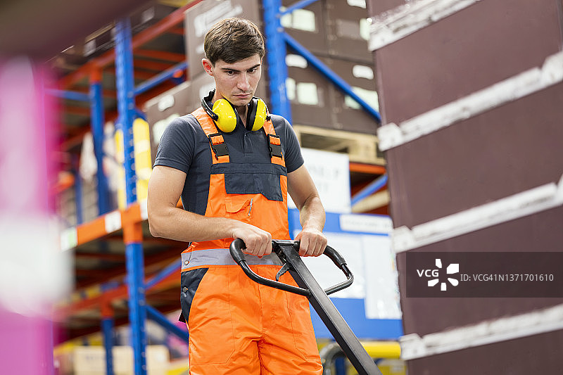 仓库工人操作手动托盘搬运车搬运货物图片素材