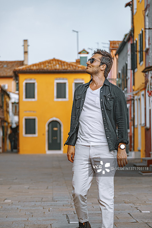 年轻游客在意大利威尼斯布拉诺镇的街道上行走图片素材