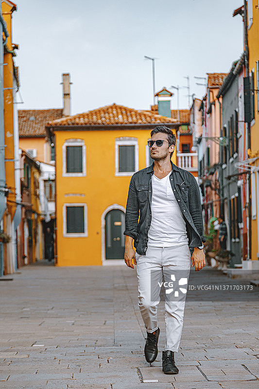 年轻游客在意大利威尼斯布拉诺镇的街道上行走图片素材
