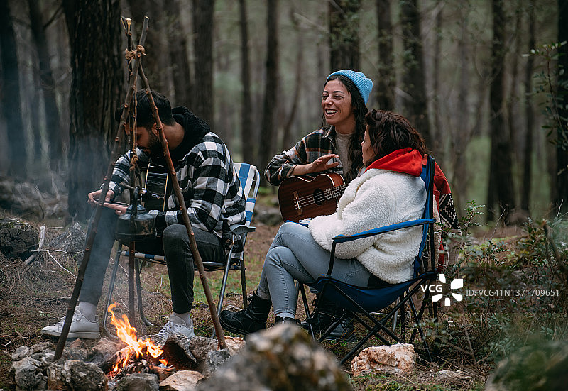 朋友在篝火旁弹吉他图片素材