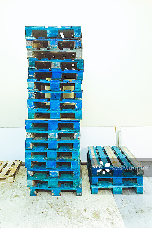 仓库中堆叠的蓝色托盘图片素材