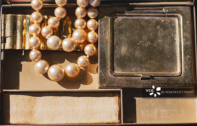 金色复古钱包里的金色珍珠项链图片素材