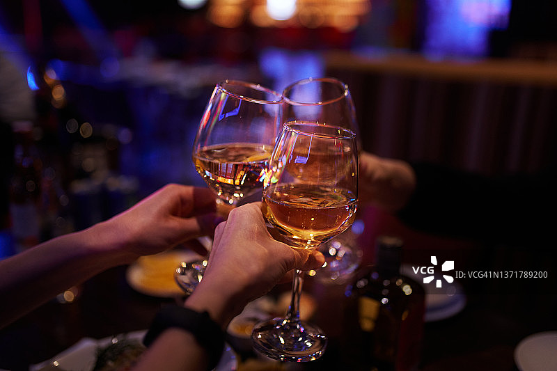 在俱乐部派对手持香槟酒杯碰杯的手图片素材