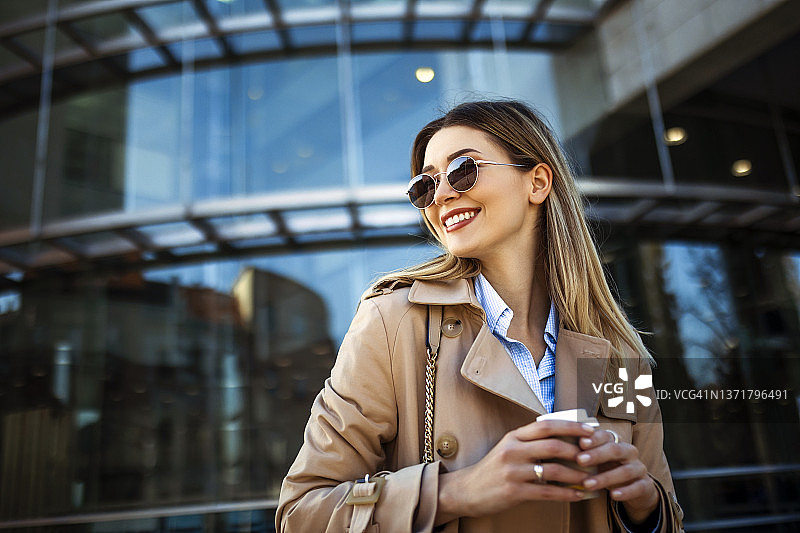 在户外喝咖啡、回头的优雅女商人图片素材