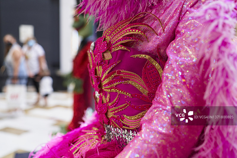 购物中心橱窗里的人体模型穿着闪亮的狂欢节服装，具有不同的纹理和材料图片素材