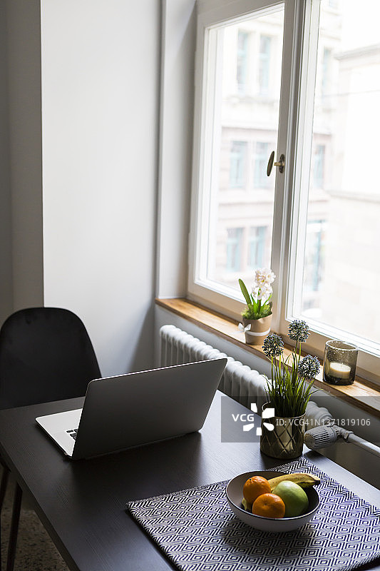 笔记本电脑、水果盘和餐桌（居家窗边）图片素材