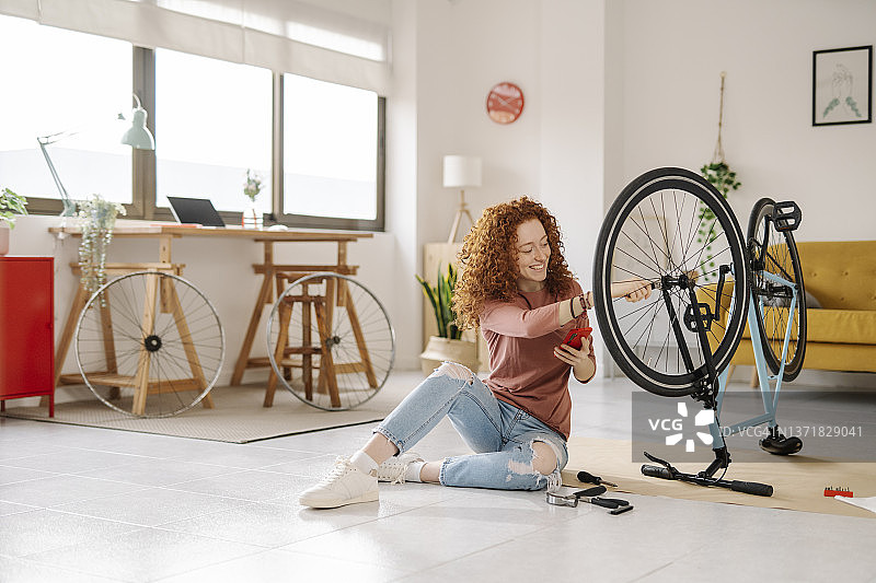 在家观看教程并修理自行车的女人图片素材