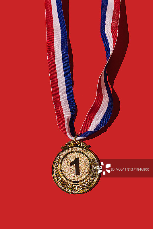 红色背景上的体育成就金牌，冠军、荣誉和体育竞赛概念图片素材
