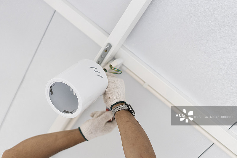 特写：技术人员安装天花板灯图片素材