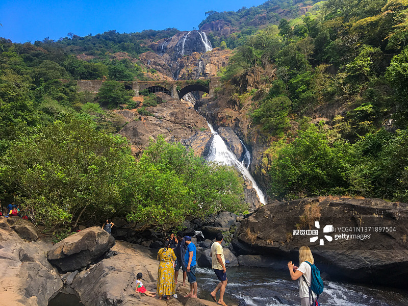 杜德萨加尔山瀑布的壮丽景色。人们在河边散步，欣赏莫伦国家公园的自然风光，放松身心。图片素材