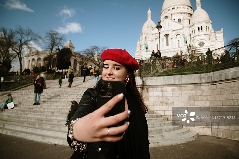 年轻女人在巴黎圣心大教堂自拍图片素材