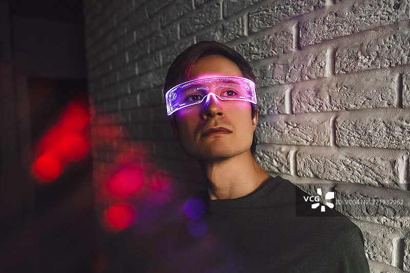 戴霓虹眼镜的年轻男子肖像，未来概念图片素材
