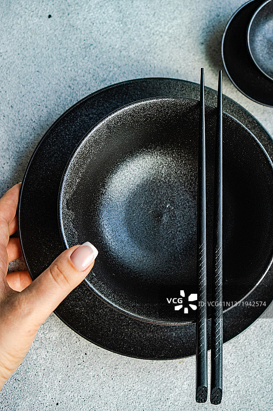 俯视角度拍摄的女人用亚洲餐具布置餐桌图片素材