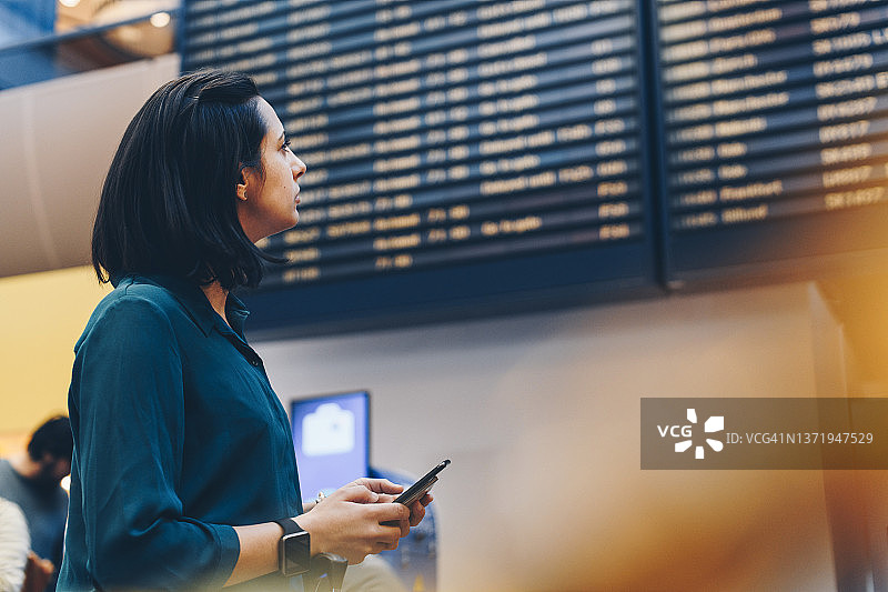 中年女商人查看机场的到港离港信息图片素材