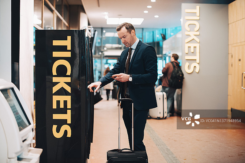 在机场购买机票的成熟商人图片素材