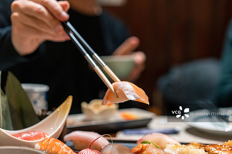 亚洲男人在餐厅吃寿司图片素材