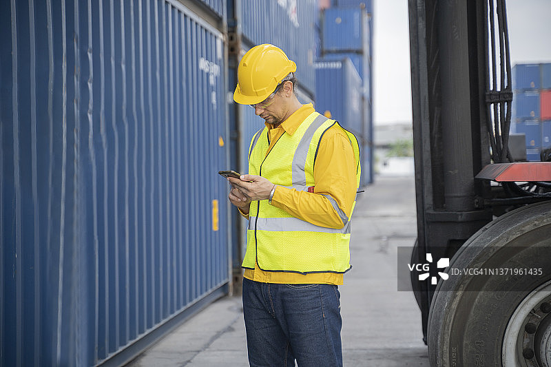 港口戴安全帽叉车男人使用手机图片素材