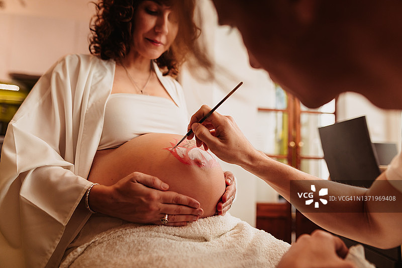 准爸爸为怀孕的妻子画肚子图片素材