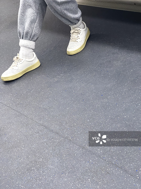 穿白鞋的女孩在地铁上。图片素材