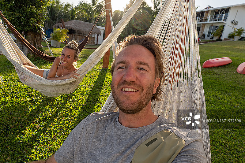 日落时在吊床上自拍的年轻夫妇图片素材