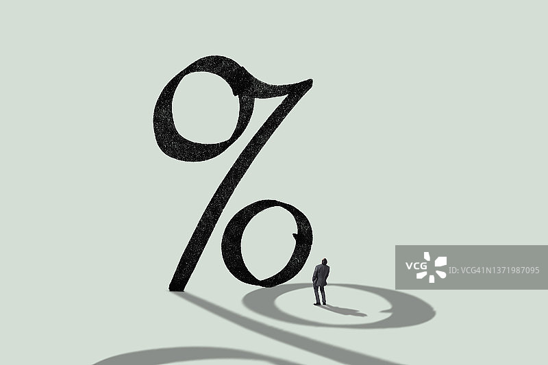 站在大百分比符号阴影中的男人图片素材