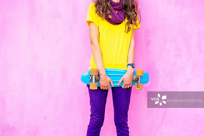 年轻女子携带蓝色复古滑板的身体照片图片素材