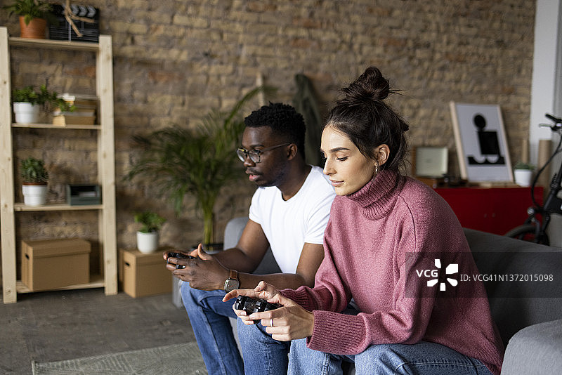 多元化情侣室友在公寓里玩电子游戏图片素材