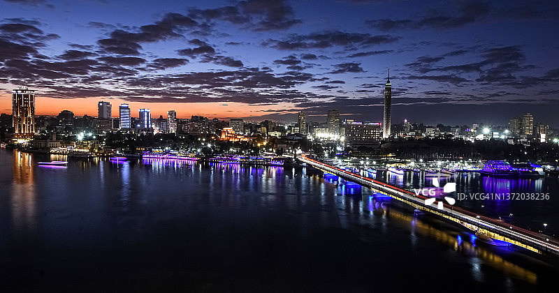 埃及开罗天际线:尼罗河滨水区与扎马莱克区(格齐拉岛),开罗塔和十月六日大桥在黄昏时分被照亮图片素材