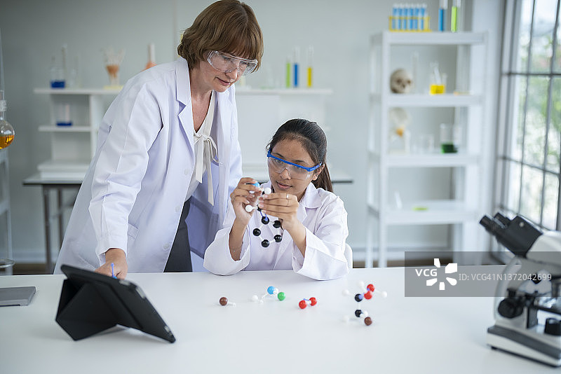 使用塑料原子模型教具的小学生图片素材