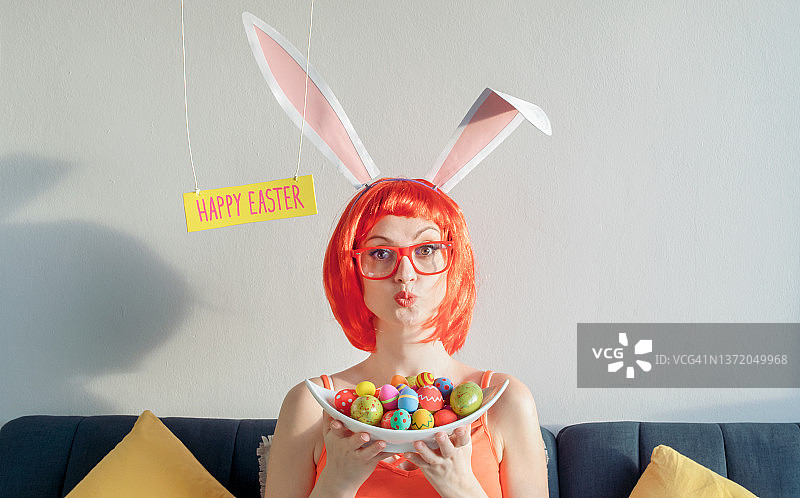 戴着兔子耳朵，拿着复活节彩蛋的女人图片素材