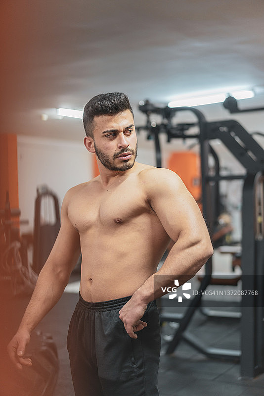 英俊的男人在健身房锻炼后照镜子图片素材