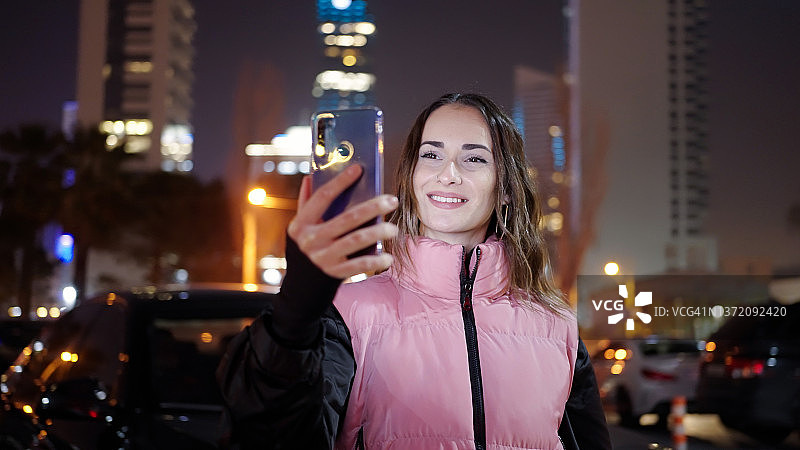 年轻女人在城市里参加视频会议图片素材