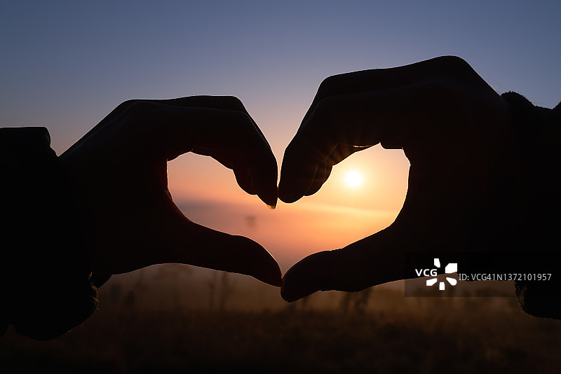 情侣在山上手势比心图片素材