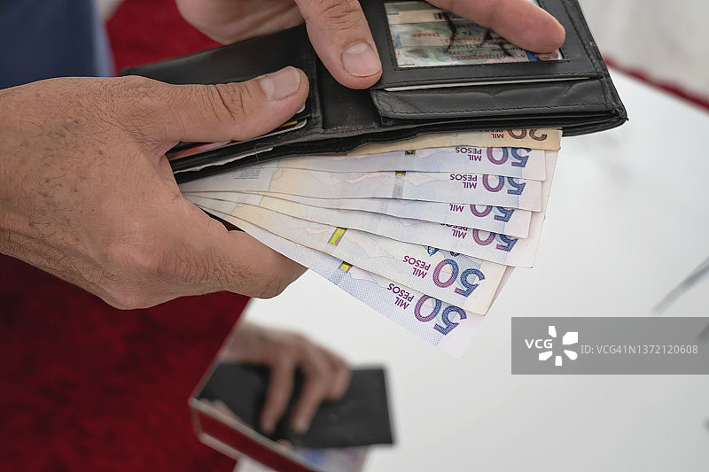 男人的手拿着钱包和哥伦比亚比索图片素材