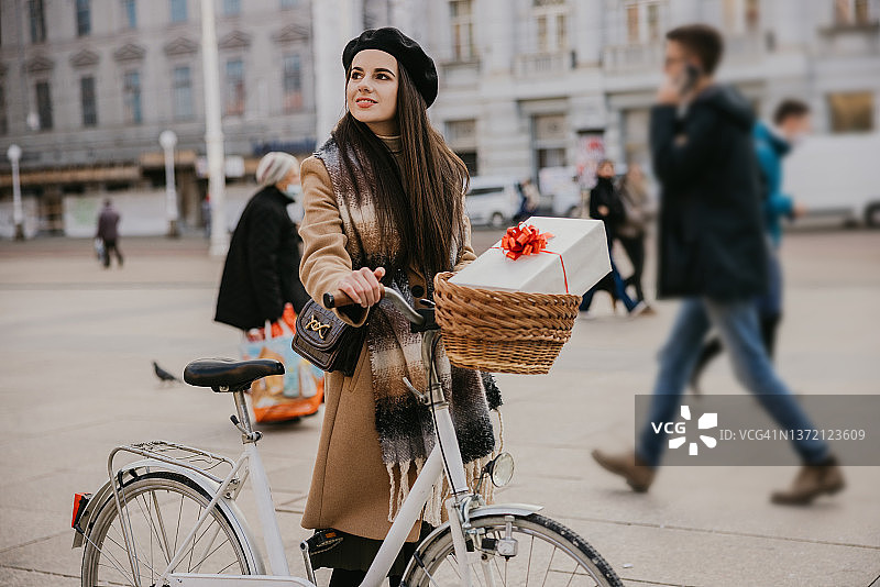 骑自行车手捧圣诞礼物的年轻女人图片素材