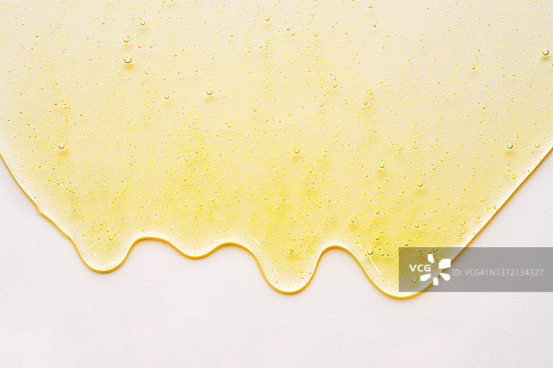 黄色凝胶、面部精华或精油、洗发水、肥皂在白色背景上的含氧气泡图片素材