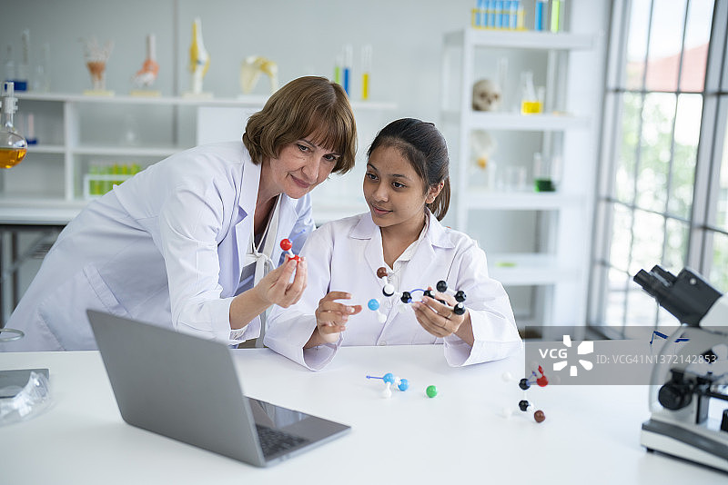 高中女生在化学实验室拿着葡萄糖分子模型图片素材