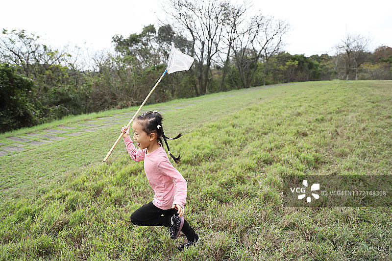在草地上捕捉昆虫的女孩图片素材