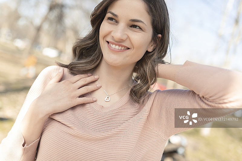 佩戴银色项链的快乐美丽女人肖像图片素材