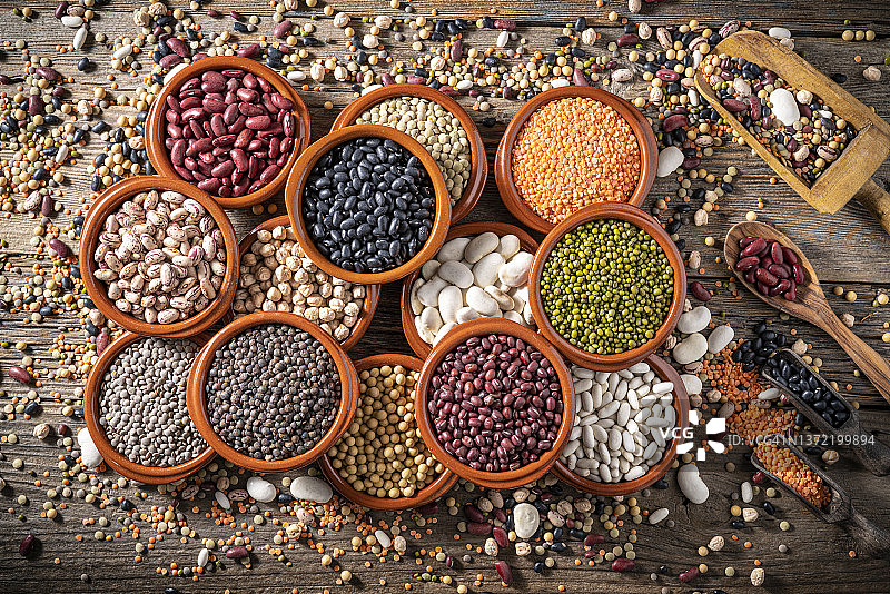 乡村木质背景下的圆形陶罐什锦豆类图片素材