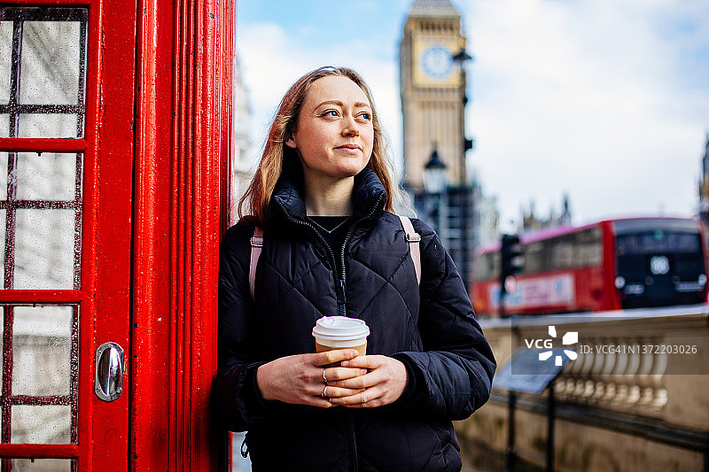 年轻女人在威斯敏斯特拿着一次性杯子喝咖啡图片素材