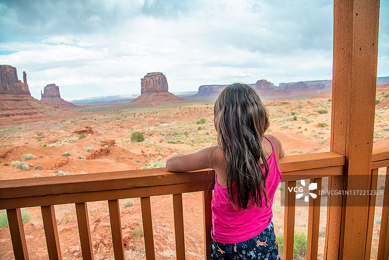 美国犹他州纪念碑谷风光：年轻游客在度假小屋阳台上欣赏美景图片素材