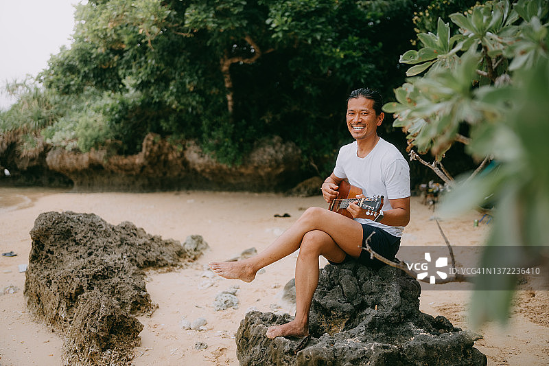 在海滩上弹吉他的男人图片素材