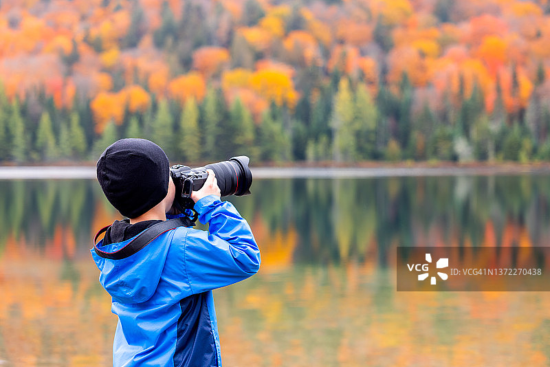 在加拿大魁北克省翠湖山国家公园秋色中拍照的可爱红发小男孩图片素材