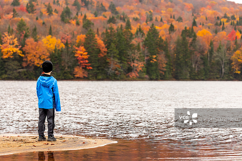 在加拿大魁北克省，蒙特朗布朗国家公园秋季门罗湖景的可爱红发男孩图片素材