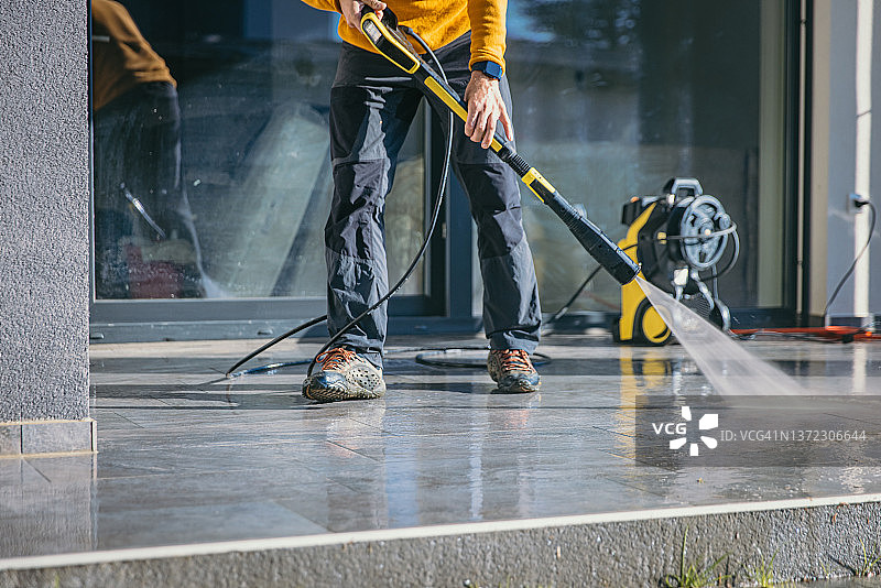 男人用高压清洁器清洁露台图片素材