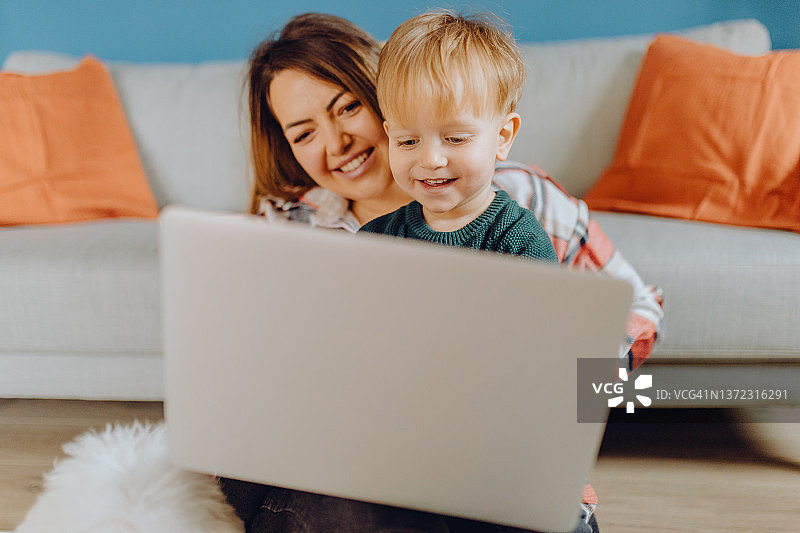 母亲和她的儿子及宠物狗一起玩玩具图片素材